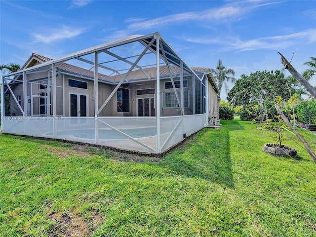 4985 NW 120th Ave, Coral Springs, FL 33076 - rear view of property featuring a lawn, glass enclosure, a tiled roof, and stucco siding
