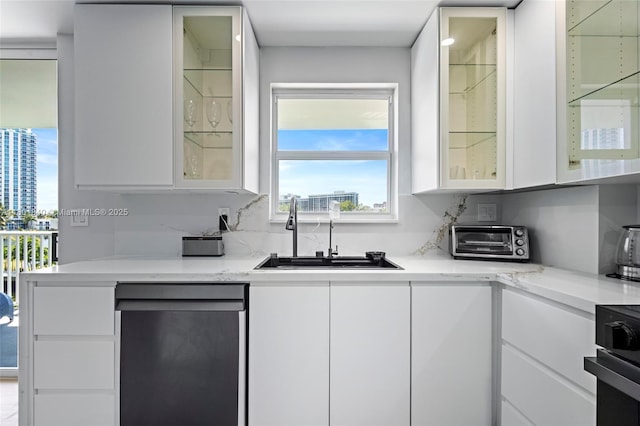137 Golden Isles Dr Unit 305, Hallandale Beach, FL 33009 - kitchen featuring dishwashing machine, a sink, white cabinetry, and glass insert cabinets