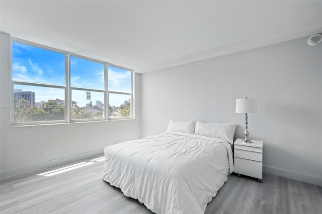137 Golden Isles Dr Unit 305, Hallandale Beach, FL 33009 - bedroom with wood finished floors, baseboards, and multiple windows