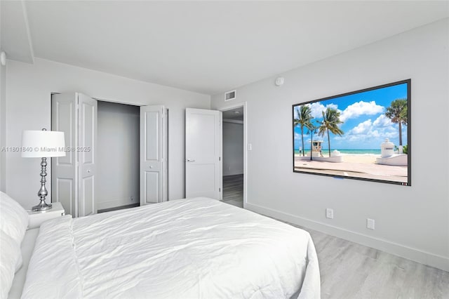 137 Golden Isles Dr Unit 305, Hallandale Beach, FL 33009 - bedroom featuring wood finished floors, baseboards, and a closet