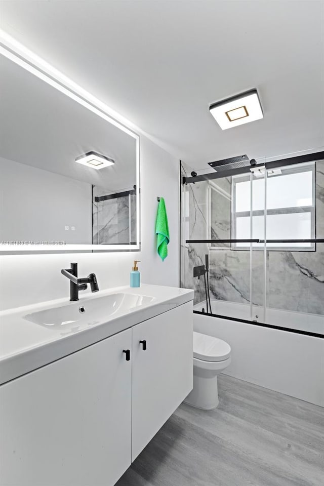 137 Golden Isles Dr Unit 305, Hallandale Beach, FL 33009 - full bath featuring wood finished floors, toilet, enclosed tub / shower combo, and vanity