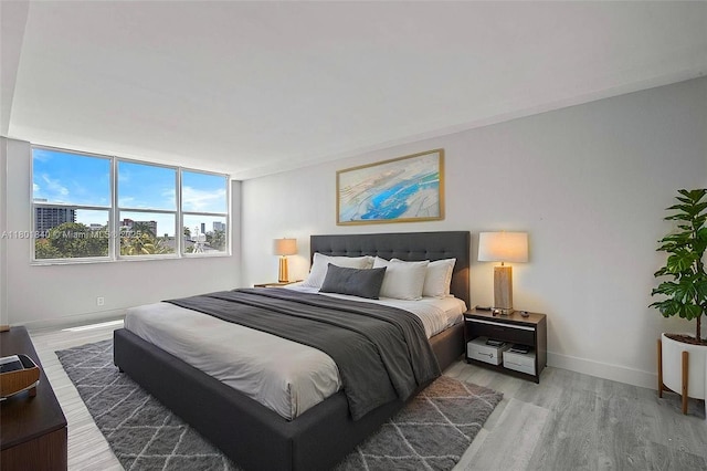 137 Golden Isles Dr Unit 305, Hallandale Beach, FL 33009 - bedroom featuring light wood-style floors and baseboards