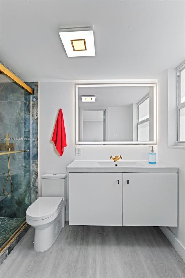 137 Golden Isles Dr Unit 305, Hallandale Beach, FL 33009 - bathroom with wood finished floors, a shower stall, vanity, and toilet