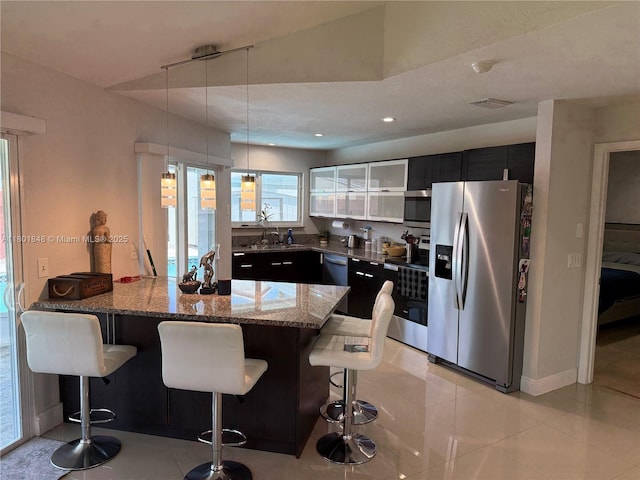 1751 SW 87th Ter, Miramar, FL 33025 - kitchen with appliances with stainless steel finishes, dark cabinets, a peninsula, a breakfast bar area, and recessed lighting