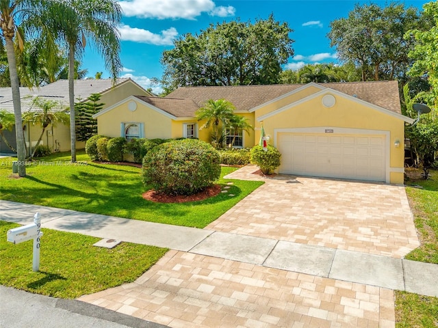 single story home featuring a front yard, stucco siding, an attached garage, and decorative driveway