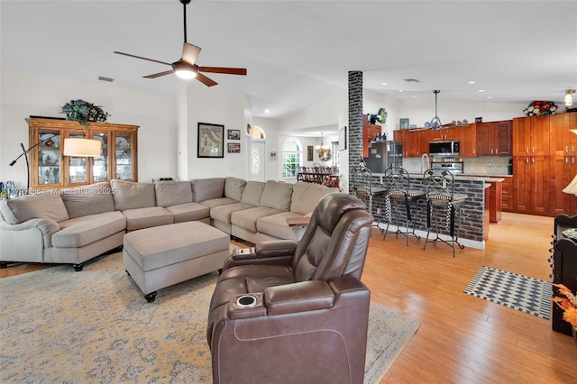 living area featuring a ceiling fan, light wood finished floors, lofted ceiling, and recessed lighting