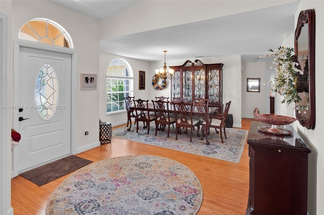 entrance foyer featuring a chandelier, light wood-style floors, and baseboards