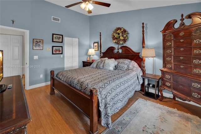bedroom featuring wood finished floors, baseboards, a closet, and ceiling fan