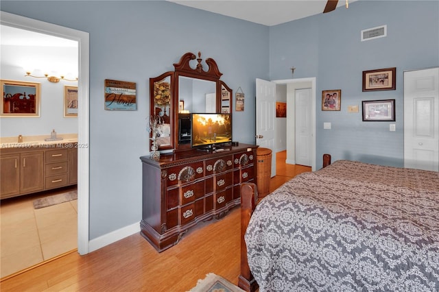 bedroom with baseboards, light tile patterned floors, connected bathroom, and a ceiling fan