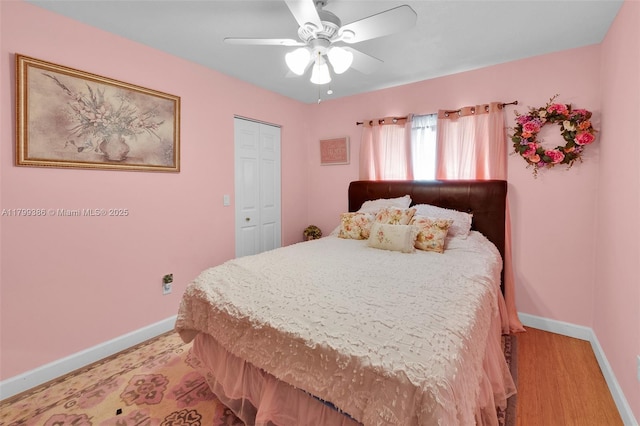bedroom featuring baseboards, ceiling fan, light wood-style flooring, and a closet