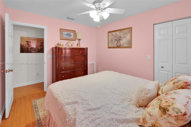 bedroom featuring light wood-type flooring, a closet, a ceiling fan, and baseboards