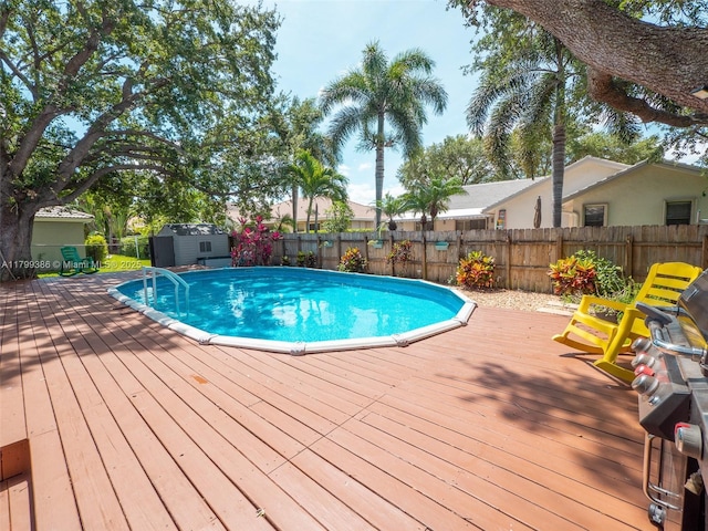 view of pool featuring a shed, a deck, and an outbuilding