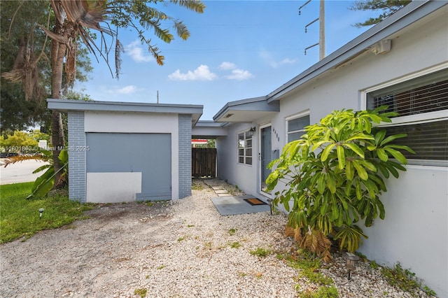6400 Sheridan St, Hollywood, FL 33024 - view of home's exterior with an outbuilding, fence, stucco siding, and brick siding