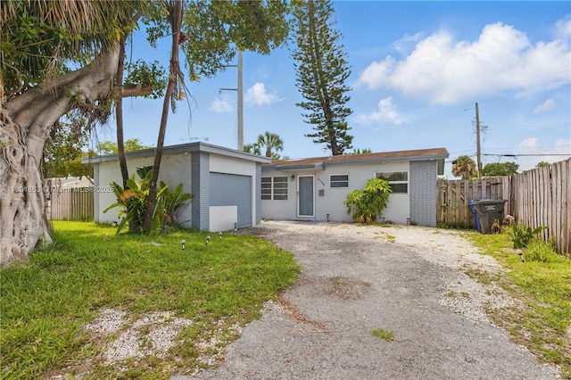 6400 Sheridan St, Hollywood, FL 33024 - view of front of property with fence, an attached garage, stucco siding, and asphalt driveway