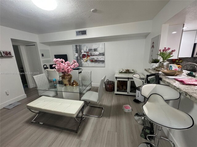 8098 NW 99th Ter, Hialeah Gardens, FL 33016 - living room featuring wood finished floors, a textured ceiling, and baseboards