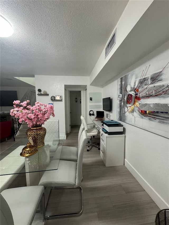 8098 NW 99th Ter, Hialeah Gardens, FL 33016 - dining space featuring baseboards, an office area, a textured ceiling, and wood finished floors