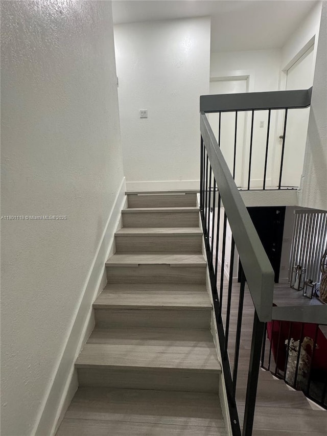8098 NW 99th Ter, Hialeah Gardens, FL 33016 - stairway with wood finished floors, baseboards, and a textured wall