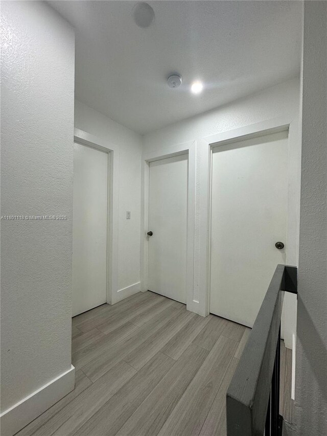 8098 NW 99th Ter, Hialeah Gardens, FL 33016 - corridor with light wood-type flooring and baseboards