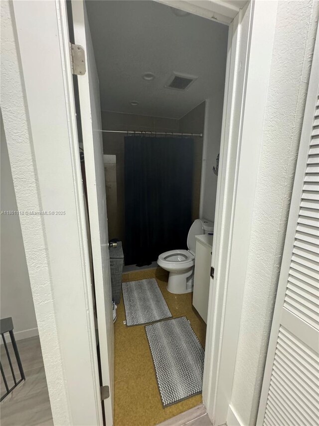 8098 NW 99th Ter, Hialeah Gardens, FL 33016 - bathroom with toilet and a shower with shower curtain