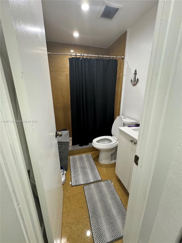 8098 NW 99th Ter, Hialeah Gardens, FL 33016 - bathroom with tiled shower, toilet, and tile patterned floors