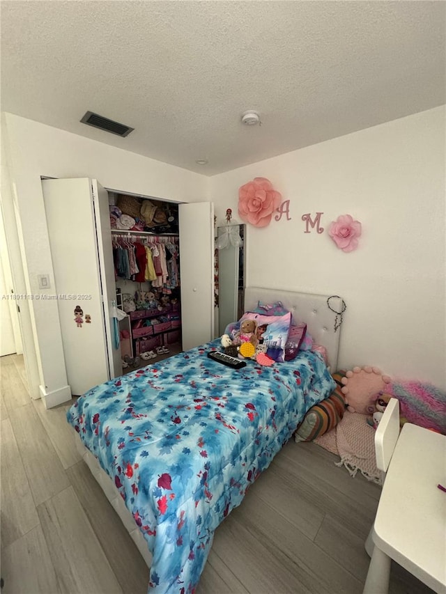 8098 NW 99th Ter, Hialeah Gardens, FL 33016 - bedroom with wood finished floors, a closet, and a textured ceiling