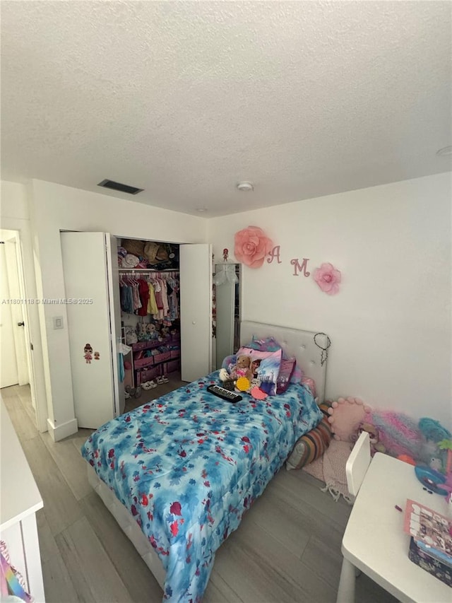 8098 NW 99th Ter, Hialeah Gardens, FL 33016 - bedroom with a textured ceiling, wood finished floors, and a closet