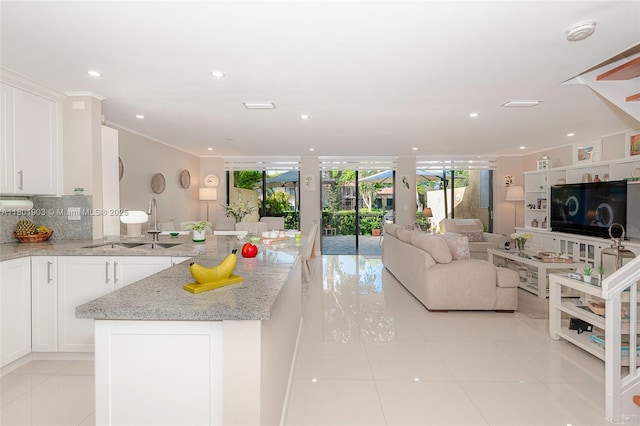 3915 Adra Ave Unit F-46A, Doral, FL 33178 - kitchen with light tile patterned floors, open floor plan, white cabinets, light stone countertops, and decorative backsplash