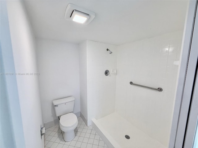 full bath featuring tiled shower, toilet, and tile patterned floors