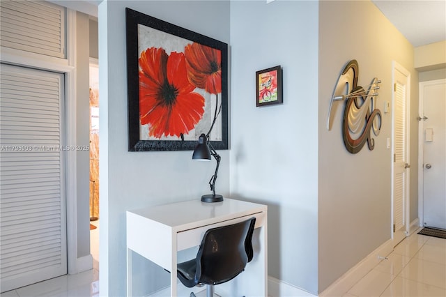 16900 NE 14th Ave Unit 201, North Miami Beach, FL 33162 - hallway with baseboards, a desk, and light tile patterned floors