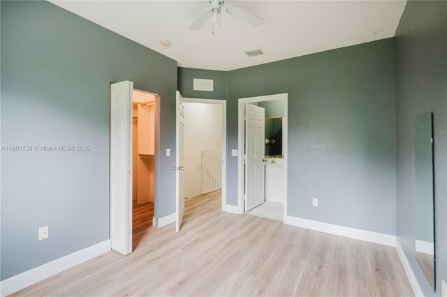 7818 Catalina Cir, Tamarac, FL 33321 - unfurnished bedroom featuring light wood-type flooring, a spacious closet, baseboards, a closet, and ensuite bathroom