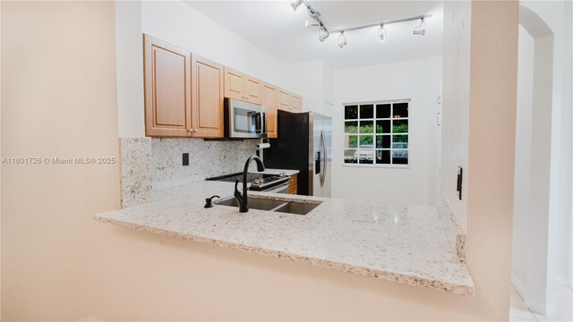 7818 Catalina Cir, Tamarac, FL 33321 - kitchen featuring stainless steel appliances, tasteful backsplash, light stone counters, a sink, and a peninsula