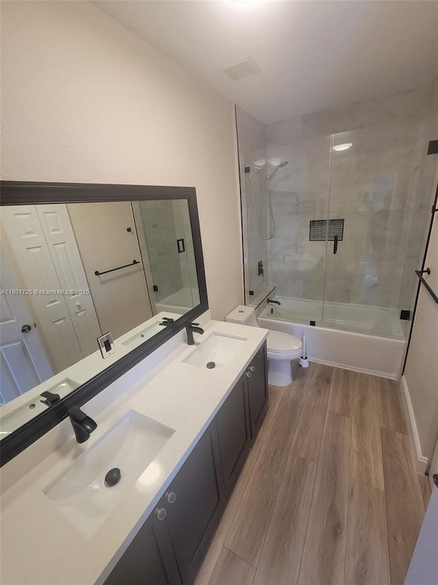 7818 Catalina Cir, Tamarac, FL 33321 - bathroom featuring wood finished floors, toilet, bath / shower combo with glass door, double vanity, and vaulted ceiling