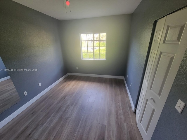 7818 Catalina Cir, Tamarac, FL 33321 - empty room featuring a textured wall, dark wood finished floors, baseboards, and ceiling fan