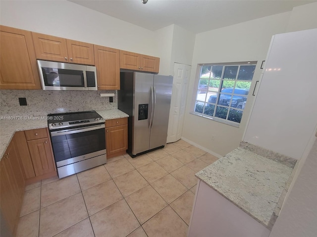 7818 Catalina Cir, Tamarac, FL 33321 - kitchen featuring stainless steel appliances, light tile patterned floors, decorative backsplash, and brown cabinets