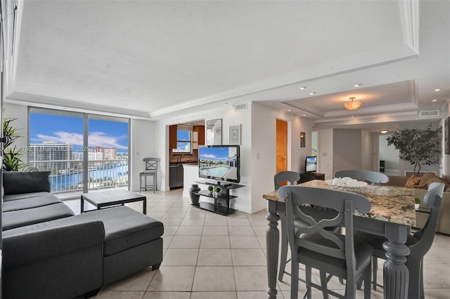 137 Golden Isles Dr Unit 1105, Hallandale Beach, FL 33009 - living room with a tray ceiling, light tile patterned flooring, and ornamental molding