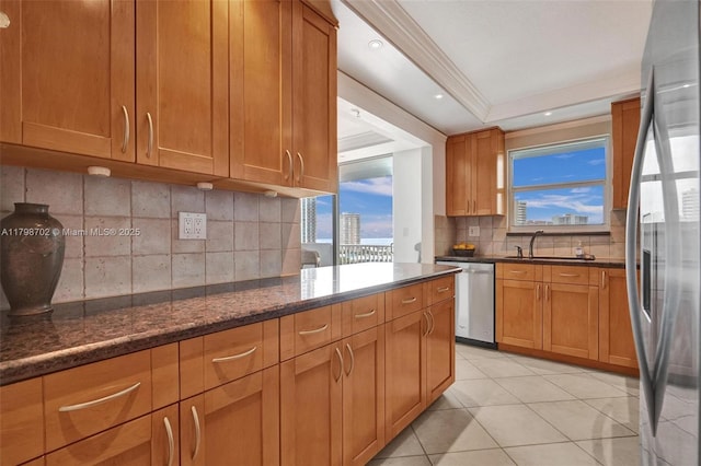 137 Golden Isles Dr Unit 1105, Hallandale Beach, FL 33009 - kitchen featuring appliances with stainless steel finishes, decorative backsplash, a sink, dark stone counters, and light tile patterned floors