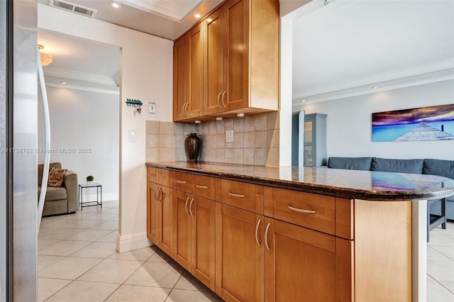137 Golden Isles Dr Unit 1105, Hallandale Beach, FL 33009 - kitchen featuring freestanding refrigerator, crown molding, light tile patterned floors, backsplash, and dark stone counters