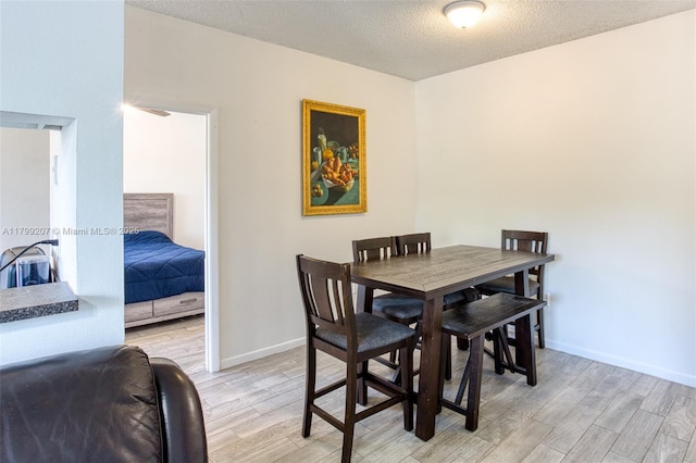 2301 NW 96th Ter Unit 16C, Pembroke Pines, FL 33024 - dining area with light wood-style floors, a textured ceiling, and baseboards