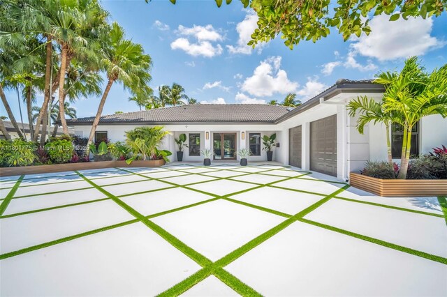 4430 Casper Ct, Hollywood, FL 33021 - rear view of house featuring a tiled roof, a garage, stucco siding, and french doors