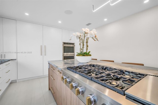 4430 Casper Ct, Hollywood, FL 33021 - kitchen with stovetop, stainless steel double oven, modern cabinets, recessed lighting, and light stone countertops