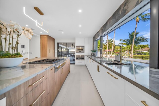 4430 Casper Ct, Hollywood, FL 33021 - kitchen with modern cabinets, dark stone countertops, stainless steel appliances, a sink, and recessed lighting