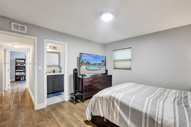 8504 Old Country Mnr Unit 205, Davie, FL 33328 - bedroom with light wood-type flooring, ensuite bath, and baseboards