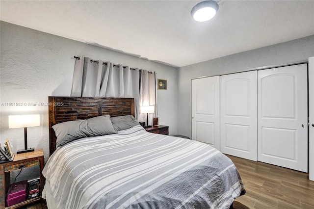 8504 Old Country Mnr Unit 205, Davie, FL 33328 - bedroom featuring wood finished floors, a closet, and a textured wall