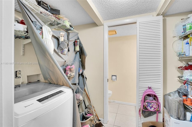 1458 N Lawnwood Cir Unit 24, Fort Pierce, FL 34950 - washroom featuring a textured ceiling, tile patterned flooring, and washer / clothes dryer