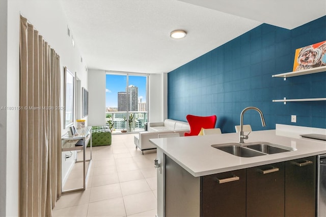 kitchen with a sink, open floor plan, light countertops, expansive windows, and a view of city