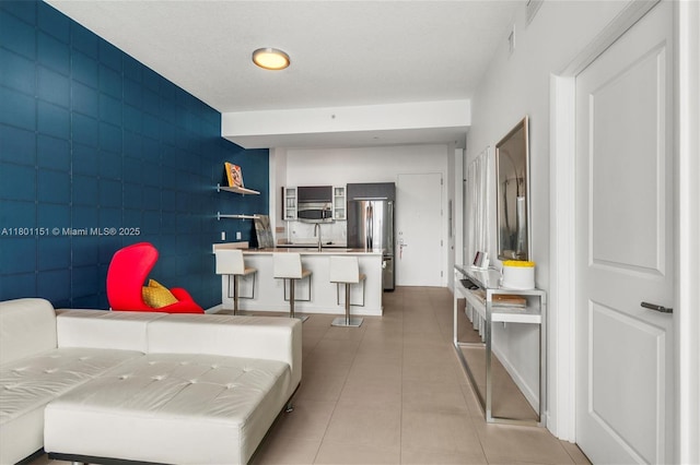living area featuring light tile patterned flooring and tile walls