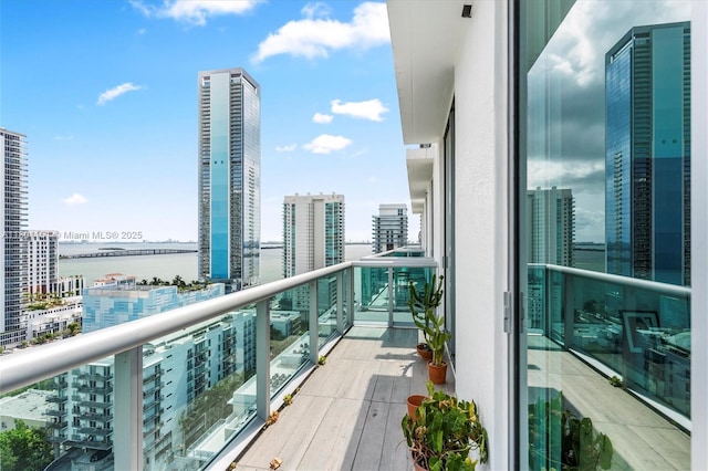 balcony featuring a water view and a city view