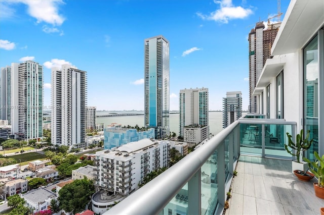 balcony featuring a view of city and a water view