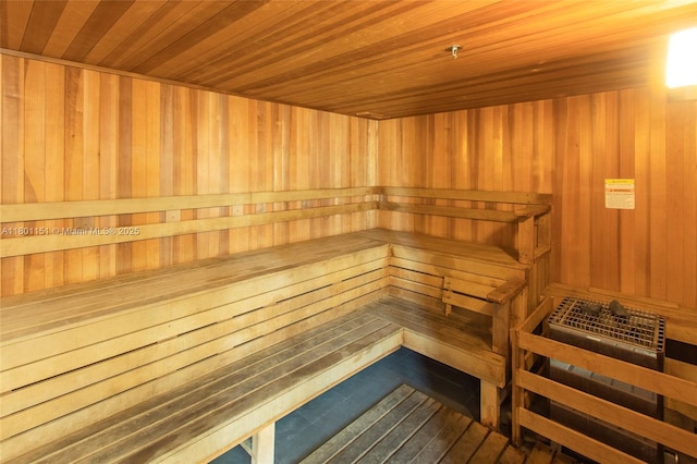 relaxing sauna featuring wooden walls and wood ceiling