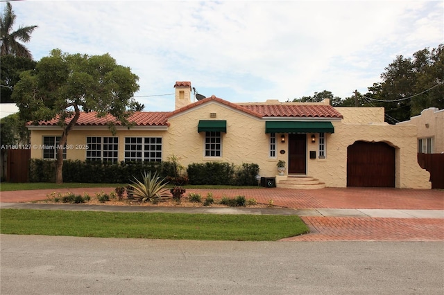 804 SE 10th St, Fort Lauderdale, FL 33316 - mediterranean / spanish-style house featuring decorative driveway, a chimney, a tile roof, and a garage